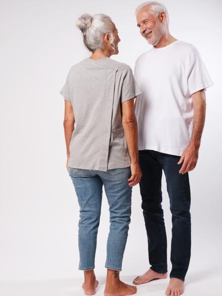 femme de dos en t-shirt gris et homme en t-shirt blanc qui la regarde