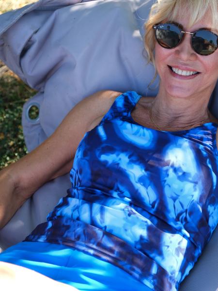 femme en maillot de bain tankini bleu allongée sur un coussin
